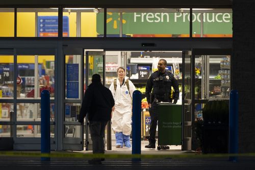 A law enforcement investigator wears a protective covering as they work the scene of a mass shooting at a Walmart, Wednesday, November 23, 2022, in Chesapeake, Virginia