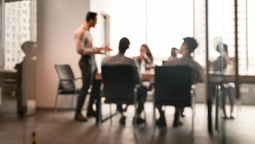 Employees are seen meeting in their workplace.