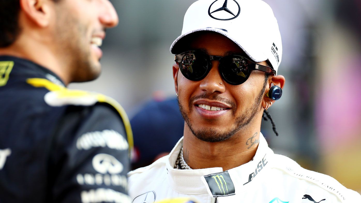 Lewis Hamilton of Great Britain and Mercedes GP talks with Daniel Ricciardo 