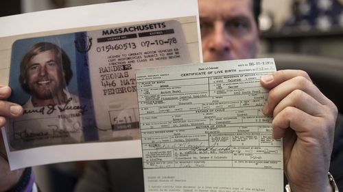 U.S. Marshal Peter J. Elliott holds the birth certificate and a copy of Ted Conrad's driver's license. 