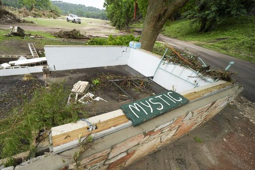A Camp Mystic sign is seen near the entrance to the establishment along the banks of the Guadalupe River after a flash flood swept through the area in Hunt, Texas, Saturday, July 5, 2025. (AP Photo/Julio Cortez)