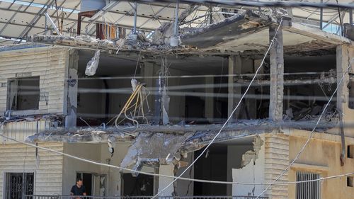 A man checks his destroyed house that was hit in an Israeli airstrike in Nabatieh town, south Lebanon, Friday, June 27, 2025. (AP Photo/Mohammed Zaatari)