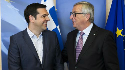 Greek Prime Minister Alexis Tsipras, left, is greeted by European Commission President Jean-Claude Juncker. (AAP)