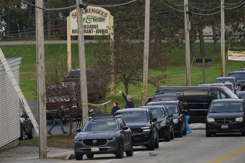 A body is wheeled out on a stretcher at Schemengees Bar and Grille, Thursday, Oct. 26, 2023, in Lewiston, Maine.