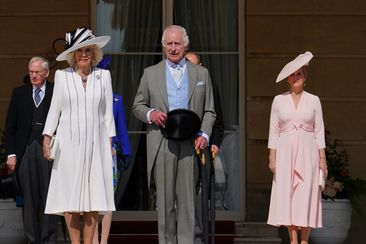 King Charles III and Queen Camilla, stand with the Duke and Duchess of Edinburgh (R) and the Duke and Duchess of Gloucester (L) as they listen to the National Anthem during a Royal Garden Party at Buckingham Palace on May 8, 2024 in London 