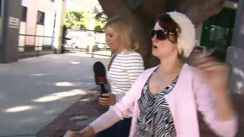 The woman allegedly stubbed the lit cigarette into Bernhardt's face outside court. (9NEWS)