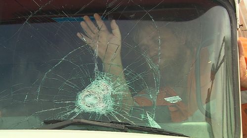 The truckie shows the damage to his windscreen.
