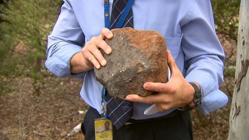 Police show one of the rocks believed to have been thrown in the incident.