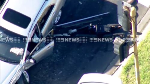 A bomb squad robot examines a car involved in a police pursuit west of Melbourne. (9NEWS)