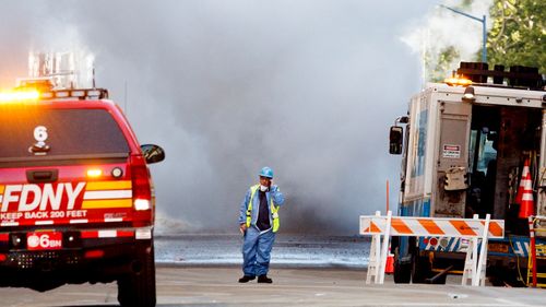 A utility employee works at the scene of a high pressure steam explosion on Fifth Avenue in New York. (AAP)