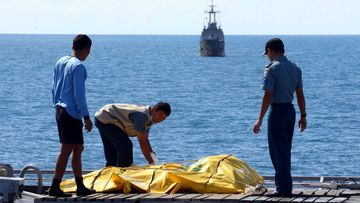 Indonesian rescuers inspect body bags of victims of crashed AirAsia flight QZ8501. (AAP)