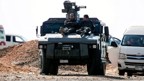 Two policeman sit on an armoured vehicle near the scene of the attack, south-west of Cairo. (AAP)