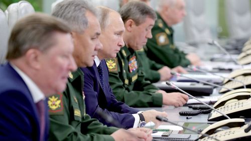 Russian President Vladimir Putin (centre) watches a video link of a successful test launch of the Avangard intercontinental strategic missile, with Russian Defence Minister Sergei Shoigu on his right and Head of the Russian Armed Forces Army General Valery Gerasimov on his left.