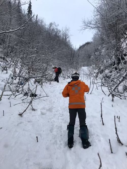 Two volunteers are shown after an avalanche in the Bear Mountain area near Chugiak, Alaska. The rescue group and troopers found the bodies of three hikers in the avalanche slide. (Matt Helm/Alaska Mountain Rescue Group via AP)