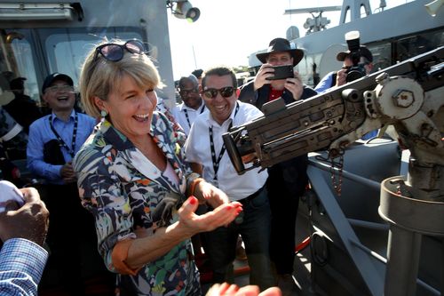 And cracks up as she attempts to cock a .50 cal gun onboard HMS Maitland. Picture: AAP