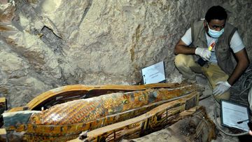 Experts inspect the sarcophagus which were found with mummies and sculptures inside a grave during archaeological works at Dra' Abu el-Naga' region in Luxor, Egypt on April 18, 2017. (AFP)