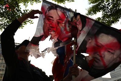 Protesters in Seoul, the capital of South Korea &ndash; burnt flags of Kim Jong-Un showing a joint stance against the imminent meeting
