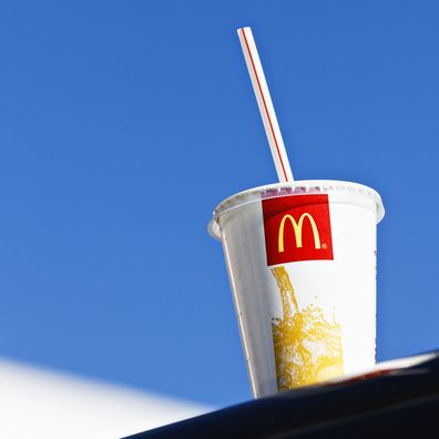 McDonalds cup sitting on ledge, blue sky in background