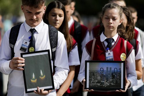 Kosovo Albanian students hold pictures of World Trade Center's twin towers while marching in the capital Pristina, Kosovo,