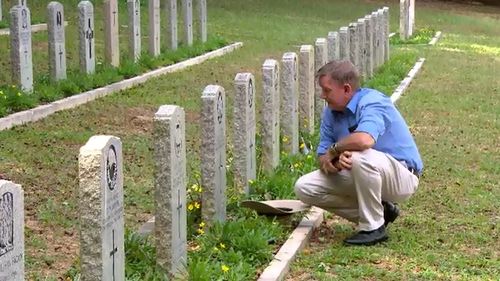 Neil Bond at the gravestone of his uncle, Reg Hillier who fought in the Vietnam War. (A Current Affair)