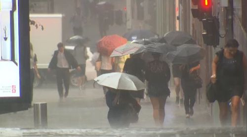 Pedestrians are lashed with rain in the CBD. (9NEWS)