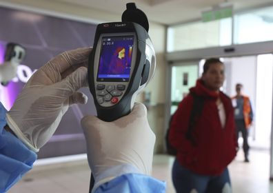 Health Ministry staff monitors body temperature at the international arrival at  Mariscal Sucre airport in Quito, Ecuador, Saturday, Feb. 29, 2020. (AP Photo/Dolores Ochoa)