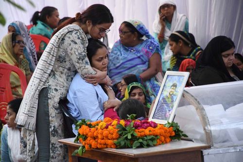 A relative consoles Aishanya Dwivedi, sitting, during the cremation ceremony  in Kanpur, India, of her husband Shubham Dwivedi who was killed by militants at Pahalgam in Indian controlled Kashmir, Thursday, April 24, 2025. (AP Photo/Vaibhav Shukla)