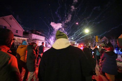 As pessoas reagem depois que fogos de artifício foram disparados perto do local de um tiroteio na quarta-feira, 14 de janeiro de 2026, em Minneapolis. (Foto AP/Abbie Parr)