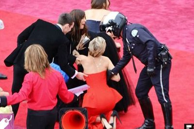 Stacks on! One year after tripping up the stairs at the Oscars, Jennifer Lawrence met the ground after clumsily falling over her own train on the red carpet.<br/> <br/>Well that's one way to get attention, JLaw.