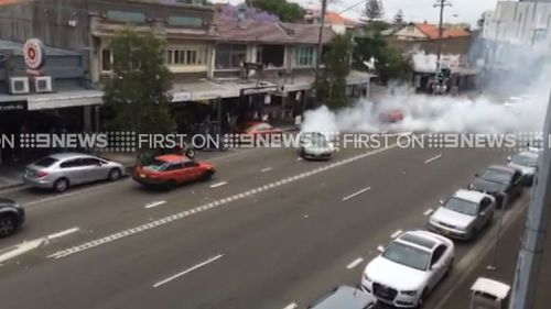 Cars stopped and residents leaned over their balcony as they watched the driver swerve past. (9NEWS)