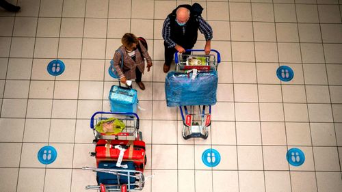 People wait at OR Tambo's airport in Johannesburg, in South Africa. The Omicron variant has become the most dominant strain circulating South Africa.