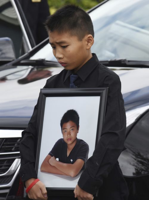 Alex Wang holds a picture of his brother Peter after his funeral in Coral Springs, Florida. (AAP)