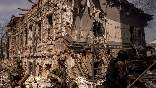 Members of the Ukrainian military walk amid debris after a shopping centre and surrounding buildings were hit by a Russian missile strike in Kharkiv, Ukraine. 