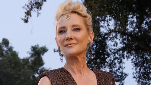 Actress Anne Heche poses atop a car as she arrives at the Drive-In to Erase MS gala, Friday, Sept.  4, 2020, in Pasadena, Calif.  (AP Photo/Chris Pizzello)