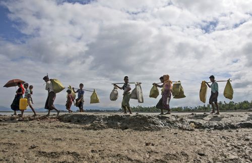 Rohingya Muslims, who crossed over from Myanmar into Bangladesh, walk towards a refugee camp in Shah Porir Dwip. (AP)