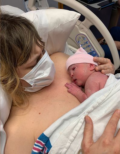 Valeri Hedges holds her newborn daughter Adrienne shortly after she gave birth in May. She had to wear a mask the entire time she was in the hospital because of the coronavirus pandemic