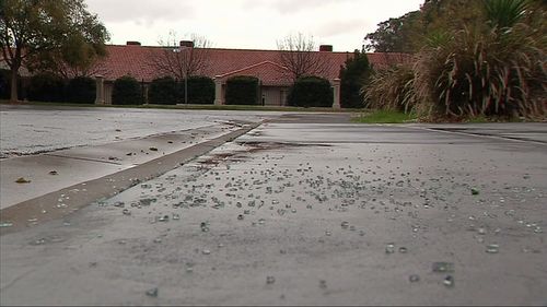 Smashed glass covers the ground on Birch Avenue. (9NEWS)