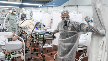 Medical staff members transport a patient on a stretcher at the Pedro DellAntonia Sports Complex field hospital as coronavirus cases soar on March 11, in Santo Andre, Brazil. (Alexandre Schneider/Getty Images South America/Getty Images)
