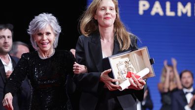 Justine Triet (R) receives The Palme D'Or Award for 'Anatomy of a Fall' from Jane Fonda (L) during the closing ceremony during the 76th annual Cannes film festival
