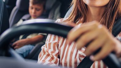 Mother takes her young son to school in a car