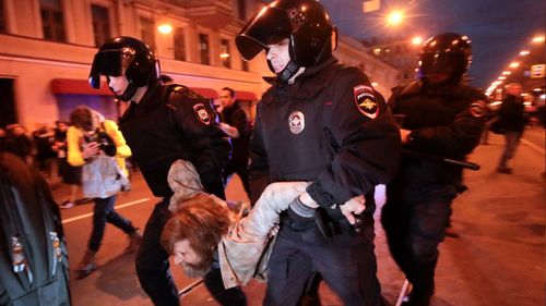 Riot police officers detain a protester during a rally in St Petersburg on Vladimir Putin's birthday. (AP)