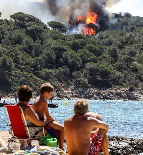 People enjoy the beach as they look at a forest fire in La Croix-Valmer, near Saint-Tropez. (AFP)