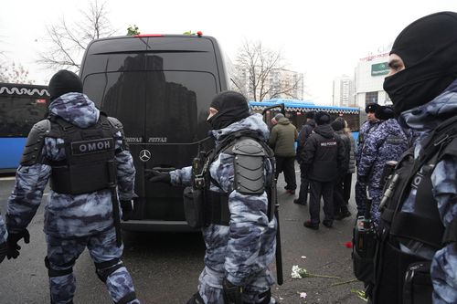 Garde de police anti-émeute à côté d'une camionnette avec le cercueil du chef de l'opposition russe Alexeï Navalny devant l'église de l'Icône de la Mère de Dieu Apaise mes chagrins, à Moscou, Russie, le vendredi 1er mars 2024. 