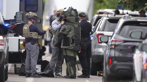 Law enforcement officials dress up in protective gear to investigative an attack on the Pearl Street Mall, Sunday, June 1, 2025, in Boulder, Colo. (AP Photo/David Zalubowski)