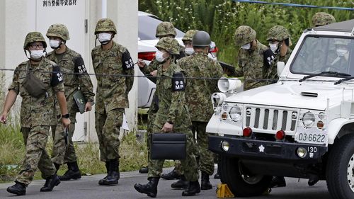 Members of Japan's Self Defense Force gather near a firing range on a Japanese army base following a deadly shooting in Gifu, central Japan, Wednesday, June 14, 2023. An army trainee was arrested Wednesday after allegedly shooting three fellow soldiers at the army base, officials said. (Kyodo News via AP)