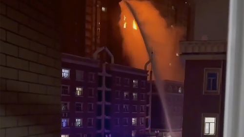 In this image taken from video, firefighters spray water on a fire at a residential building in Urumqi in western China's Xinjiang Uyghur Autonomous Region, Thursday, Nov. 24, 2022. A fire in an apartment building in northwestern China's Xinjiang region has killed several people and injured others, authorities said Friday, in the second major fire accident in the country this week. 