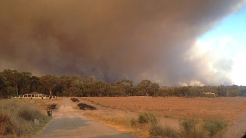 Smoke is seen rising on the horizon from Wannaroo Road. (Cassie Scoble)