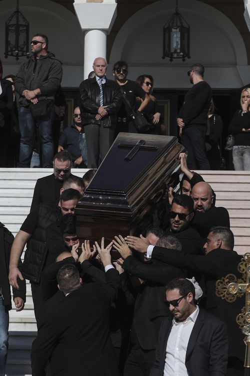 The coffin is carried down the steps of Saint Nektarios Church in Athens.