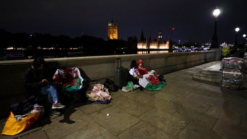 Mourners wait opposite the Palace of Westminster