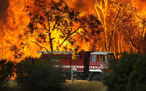 A Country Fire Authority (CFA) fire truck is pictured in front of flames while fighting a bushfire at the Bunyip State Forest near the township of Tonimbuk, Saturday, Feb. 7, 